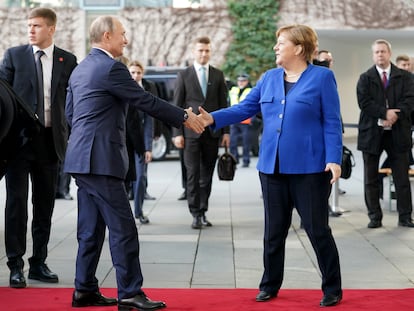 O presidente russo, Vladimir Putin, e a chanceler alemã, Angela Merkel, cumprimentam-se em Berlim, em janeiro de 2020, no início de uma conferência sobre a Líbia.