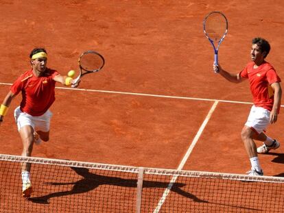 Nadal volea ante la mirada de  Marc L&oacute;pez.