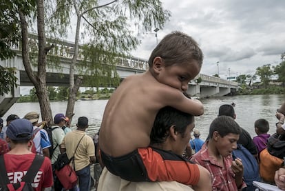 Familias de migrantes se acumularon en las orillas del río, pidiendo ayuda para poder cruzar en alguna de las balsas.