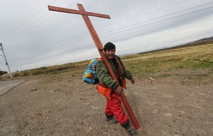 Un peregrino carga una cruz este miércoles a su paso por Huarina (Bolivia), el 17 de abril de 2019.