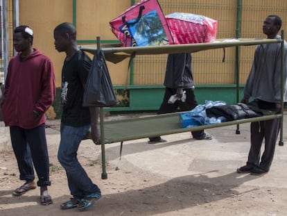 Residentes del Centro de Estancia Temporal de Inmigrantes (CETI) de Melilla trasladan unas literas, en una imagen de archivo de 2019.