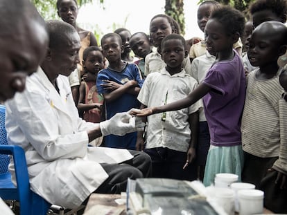 Dos enfermeros toman muestras de sangre a niños en Yalikombo, Congo, para detectar posibles casos de enfermedad del sueño.