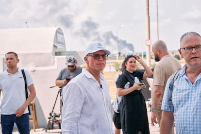 Andriy Vadaturskyy, center, with a plume of smoke behind him after a Russian attack on July 10 in Voznesensk, southern Ukraine. NIBULON