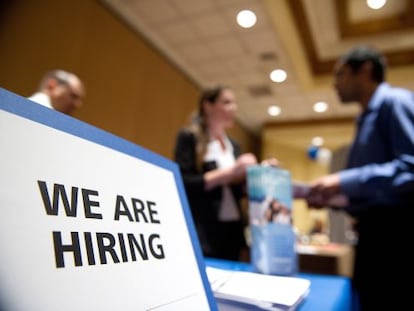 Una mesa de una oficina de empleo en San José, California, con un cartel de "estamos contratando".
