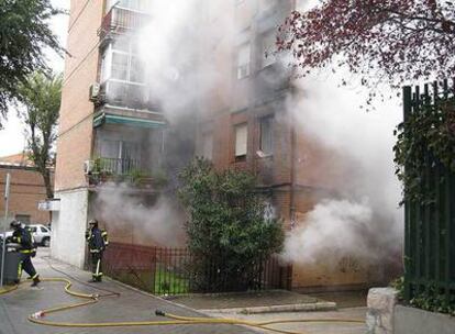 El humo sale de la vivienda incendiada en la calle Serna de Madrid.