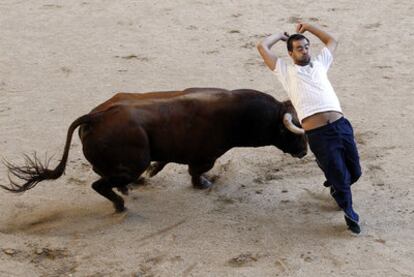 Un recortador participa en el festejo taurino en la plaza de toros de La Cubierta tras el encierro.