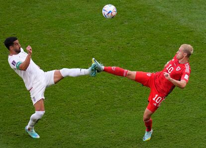 Iran's Ehsan Hajsafi, izquierda, y  Aaron Ramsey disputan un balón dividido durante el encuentro entre Irán y Gales esta mañana.