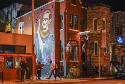 Varias personas se reúnen junto al mural de la juez Ruth Bader en una calle de Washington.