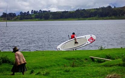 Un joven de la comunidad de Pongobamba durante una sesión de 'paddle surf' en la laguna de Piuray, en Chinchero, a unos 30 kilómetros de Cuzco.