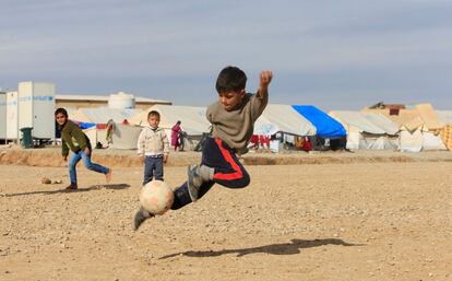 Unos niños iraquíes, que huyeron de Mosul, juegan al fútbol en un campo para desplazados en Khazer (Irak).