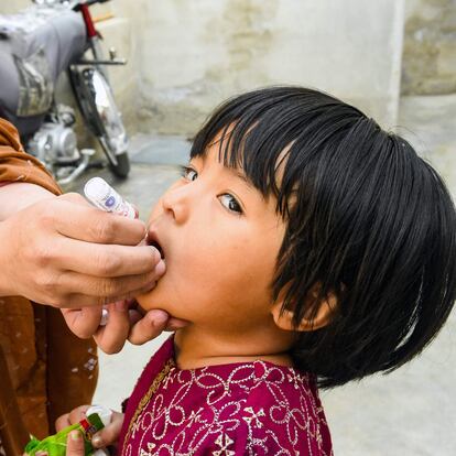 A health worker administers polio vaccine drops to a child during a vaccination campaign in Quetta on October 24, 2022. (Photo by Banaras KHAN / AFP)