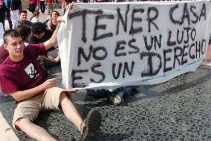 Un joven sostiene una pancarta durante la sentada esta tarde a favor de una vivienda digna en la plaza de Cataluña de Barcelona.