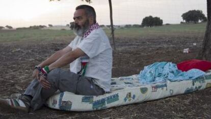 Juan Manuel S&aacute;nchez Gordillo sits on the mattress where he is sleeping on land owned by the Defense Ministry. 