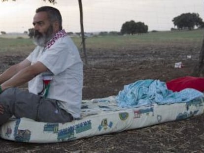 Juan Manuel S&aacute;nchez Gordillo sits on the mattress where he is sleeping on land owned by the Defense Ministry. 