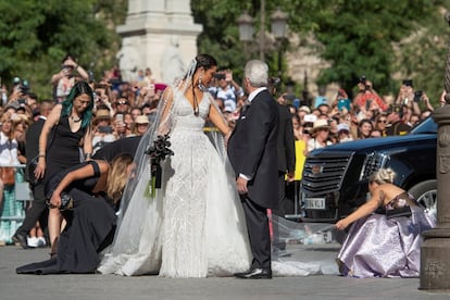 Las damas colocan la cola del vestido de Pilar Rubio, al llegar con su padre a la catedral de Sevilla.