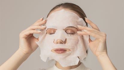 Una mujer retirándose una mascarilla.