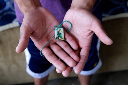 Juan Israel Rodriguez Tejeda, mexicano de 27 años, muestra una medalla con la imagen de San Juditas en "El refugio" un centro que hospeda a los migrantes durante su estancia en Guadalajara (México).