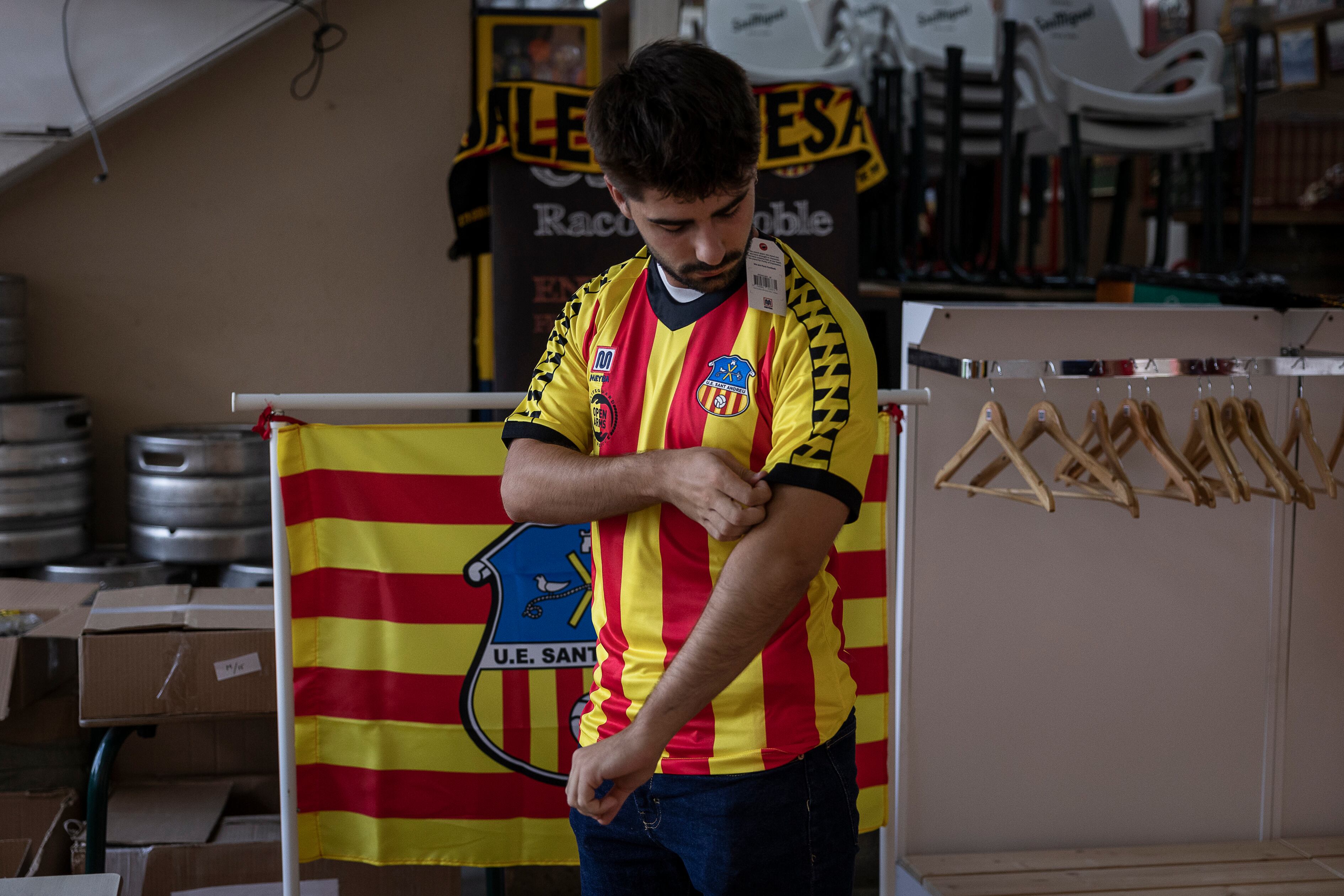 Un aficionado del Sant Andreu se prueba la camiseta del club para comprarla.