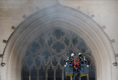 Dos bomberos trabajan en la extinción del incendio en el rosetón de la catedral. Los bomberos fueron alertados hacia las 7.45 de la mañana por unos peatones que habían visto salir llamas por por esa pieza de la fachada.