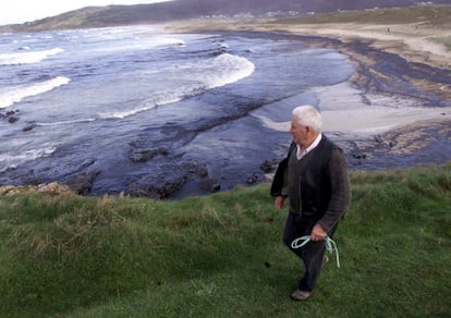 Un hombre contempla el aspecto de una playa cerca de Camelle (A Coruña), una de las zonas de la Costa de la Muerte afectadas por la marea negra provocada por el accidente del petrolero Prestige, el 17 de noviembre de 2002.