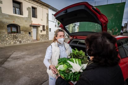 Nada más llegar a Fañanás, Pilarín y su marido Alfredo reciben a Ana con una caja entera de verduras y hortalizas. “La lechuga no la cortes con el cuchillo, córtala con las manos”, le recomienda él. De fondo, suena el pitido de la furgoneta que reparte el pan y se cruza con el camión que vende los congelados. “La cercanía que tienes con los pacientes es lo mejor, porque aquí no te encargas de uno solo, sino de toda la familia, y eso te ayuda a la hora de hacer tu trabajo”, asegura Ana.