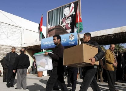 Varios trabajadores cargan con las urnas electorales en el colegio de Ein Jaloot en Amm&aacute;n, Jordania.