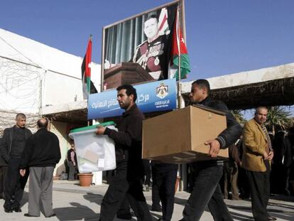 Varios trabajadores cargan con las urnas electorales en el colegio de Ein Jaloot en Ammán, Jordania.