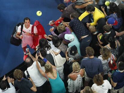 Federer firma pelotas a los aficionados tras su triunfo ante Gasquet.