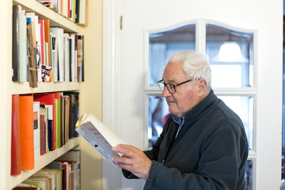 Oses consulta uno de los libros de su amplia biblioteca.