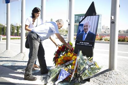 Un israelí coloca flores ante un retrato del expresidente israelí Simón Peres durante un acto público celebrado en el Parlamento o Kneset, en Jerusalén.