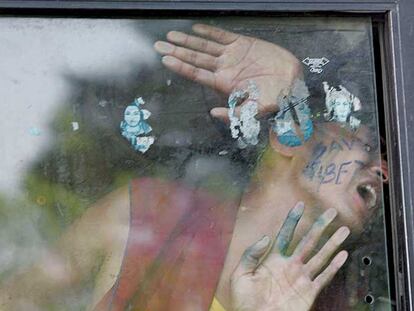 Un monje tibetano grita consignas contra China desde la ventana del furgón policial en el que lo transportan detenido, ayer en Nueva Delhi.