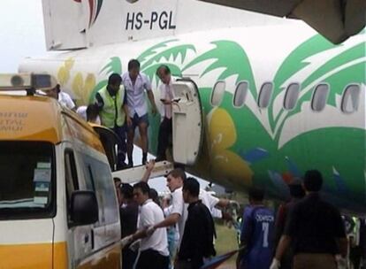 Trabajadores del aeropuerto de Koh Samui ayudan a los pasajeros a bajar del avión.