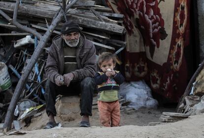 Un palestino y su hijo, sentados fuera de su casa, en el campo de refugiados de Jan Yunis (Gaza), el pasado 17 de febrero.