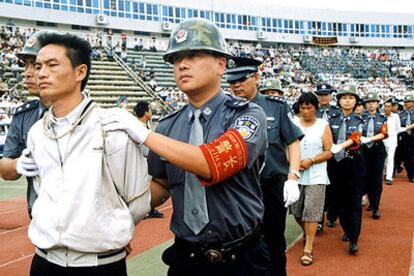 Policías chinos conducen al patíbulo a condenados por tráfico de drogas en Guiyang en 2002.