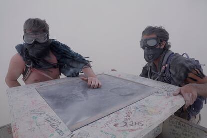 Dos participantes en el festival Coy (izquierda) y Vance (derecha) se aferran en la parte superior de una de las instalaciones conocidas como "La torre de babel", en medio de una tormenta.