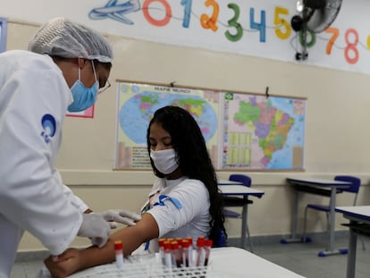 Enfermeira tira amostra de sangue de estudante em São Paulo para teste de coronavírus.