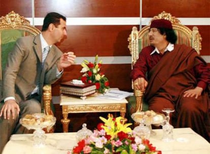 Bachar el Asad, presidente de Siria, y el mandatario libio Muammar el Gaddafi conversan el martes en Trípoli.