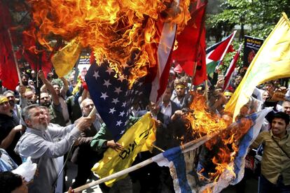 Iraníes queman las banderas de Israel y Estados Unidos durante una protesta dentro de la antigua embajada estadounidense, en Teherán (Irán).