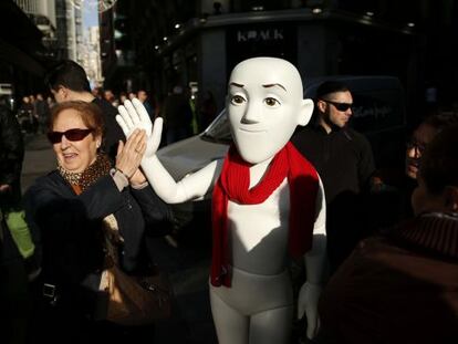 Una señora saluda a uno de los maniquíes de Justino en el centro de Madrid.