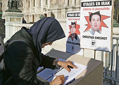 Una mujer de origen argelino firma en París un manifiesto a favor de la liberación de los periodistas.