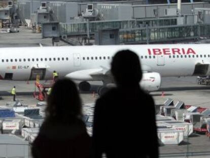Passengers watch an Iberia plane.