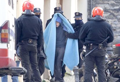 Agentes de la Ertzaintza sacan a Donnay, tapado con una manta, de su casa en el Casco Viejo de Vitoria.