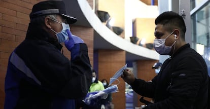 Agentes de policía reparten mascarillas en la estación de Atocha, en Madrid.