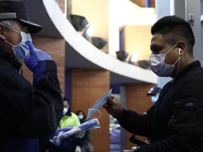 Agentes de policía reparten mascarillas en la estación de Atocha, en Madrid.