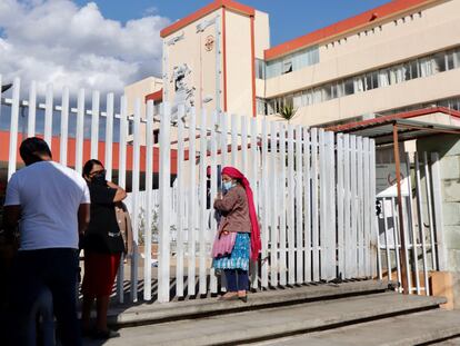 Una mujer espera a las puertas del Hospital General Doctor Aurelio Valdivieso en Oaxaca, donde están hospitalizados los menores.