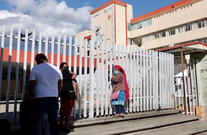 Una mujer espera a las puertas del Hospital General Doctor Aurelio Valdivieso en Oaxaca, donde están hospitalizados los menores.