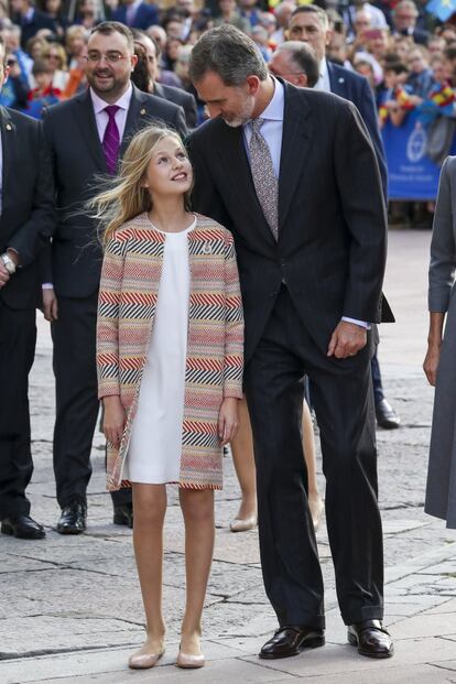 El rey Felipe se acerca a conversar con su hija, la princesa Leonor, quien luce la medalla de Asturias en su abrigo.