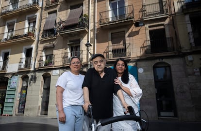 Pere Asensio, en el centro, delante del edificio público donde vive en la calle de Ferlandina del Raval de Barcelona. A izquierda y derecha, Yoquenni Benitez y Rita González. Los tres han sufrido subidas del alquiler público.