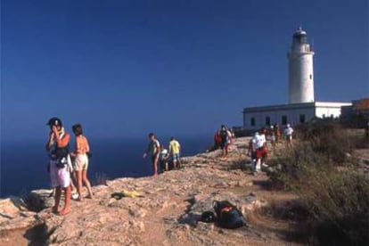 Excursionistas junto al faro de La Mola, en el extremo este de la isla de Formentera.