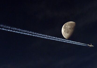 Un avión de pasajeros deja su estela en el cielo de la ciudad argelina de Argel.